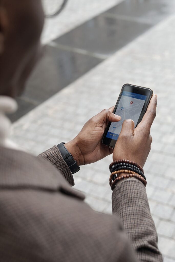 Mains tenant un smartphone affichant une carte GPS en plein air, illustration de la navigation guidée pour une personne atteinte d'Alzheimer