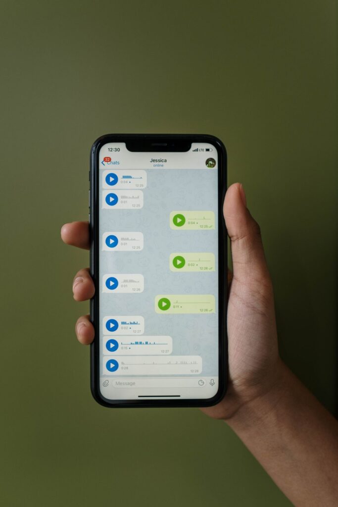 Téléphone affichant une conversation de messages vocaux, illustration de la coordination entre membres d'une famille aidante à distance